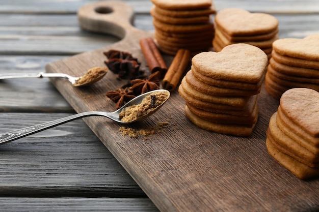 Heart shaped biscuits and cinnamon on cutting board