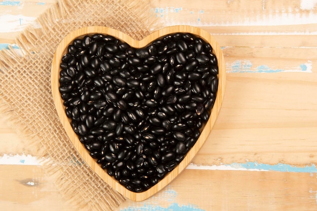 Heart shaped black bean bowl on wooden table