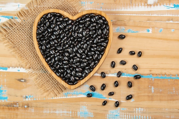 Heart shaped black bean bowl on wooden table