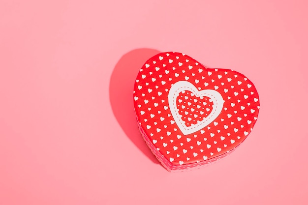 Heart shaped box mockup with hard shadow on red background. Close up copy space