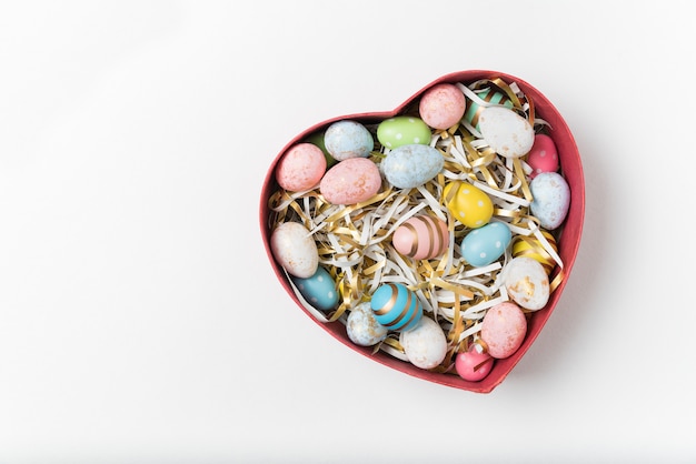 Heart shaped box with colorful holiday eggs. Happy Easter