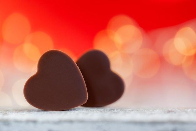 Heart shaped chocolates on red background with boke Happy Valentine's Day greeting card