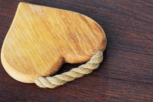 Heart shaped cutting board on rustic wooden background