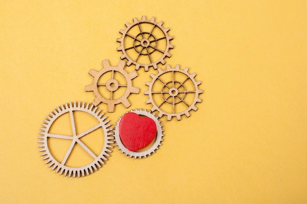 Heart shaped icon andWooden cogwheels as love concepts