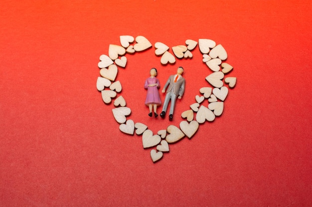 Heart shaped icons around man and woman figurine as love conception