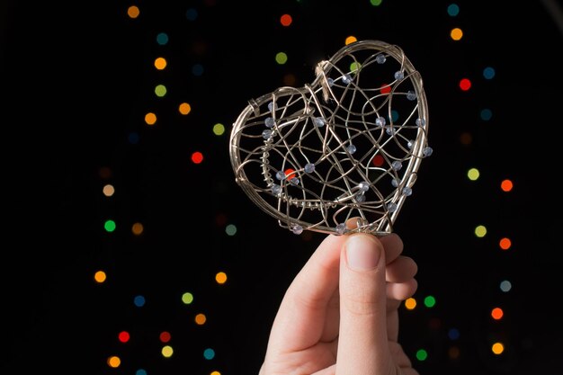 Heart shaped metal cage on bokeh light background