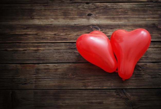 heart shaped red balloons on old wooden background