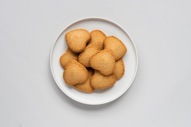 Heart shaped vanilla cookies on a plate, top view