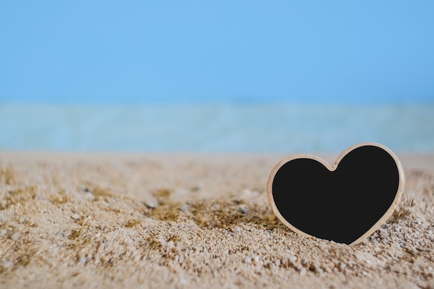 Heart sign wood with tropical sand beach ,love concept and soft focus.