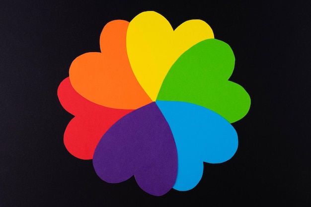 Hearts in the colors of the LGBT community flag in the form of a flower on a black background