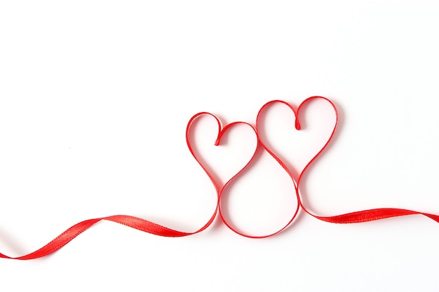 Hearts from ribbons on a white background top view