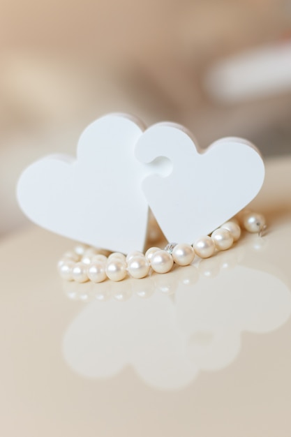 hearts puzzles and natural pearls on the table