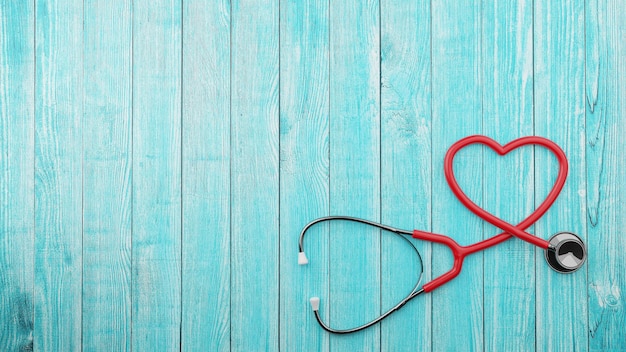 Heartshaped stethoscope on blue wooden background