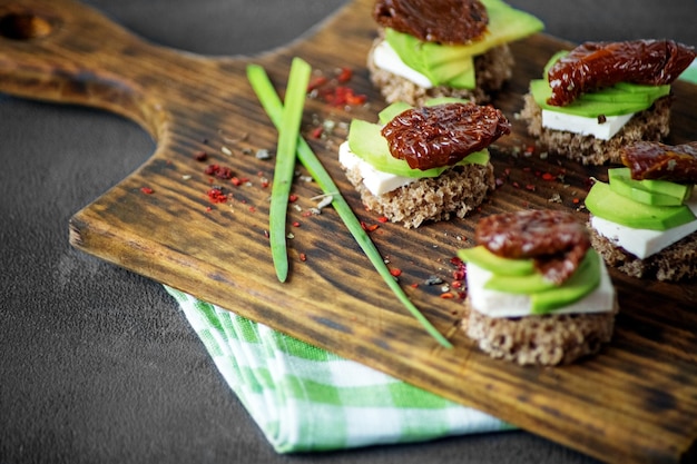 Hearty sandwiches with avocado cheese and dried tomatoes Concept for food