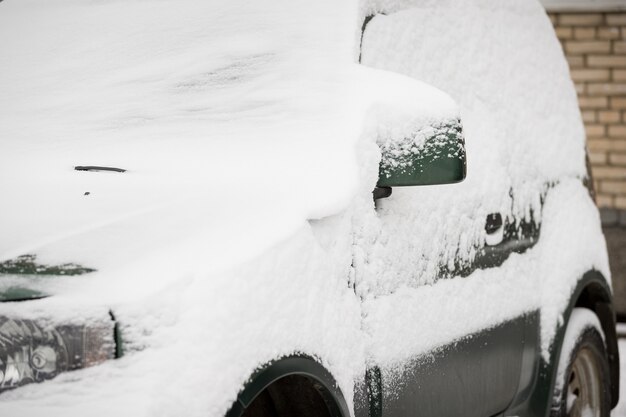 Heavy snowfall covered the cars with snow on Parking next to the house