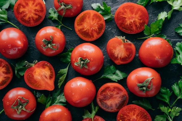 Heirloom tomatoes with green parsley for making vegetable salad Juicy vegetables on dark background Harvesting and food vitamins