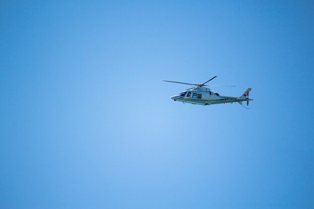 Photo helicopter flying in the blue sky. blue background