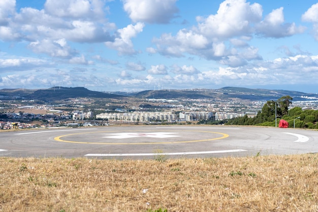 Helipad Helicopter Landing Pad near emergency hospital in Portugal with cloud sky and city on background