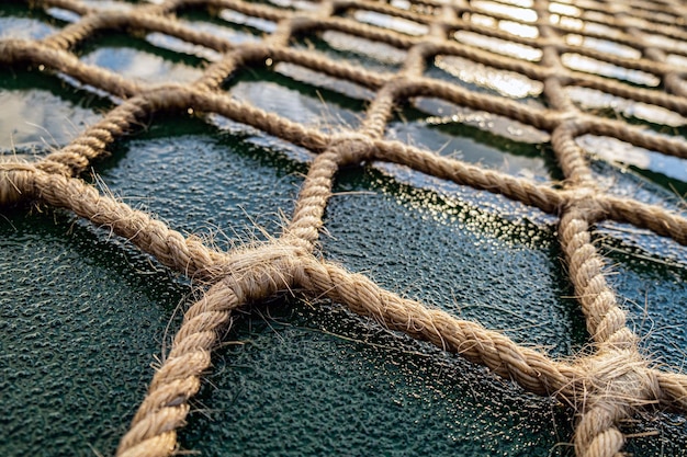 The helipad of the ship. A snow net made of hemp rope for landing a helicopter on the move of an Arctic vessel. Helipad on a ship at sunset.