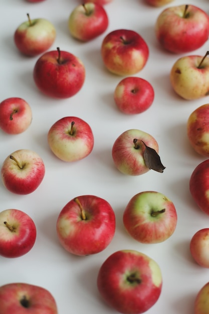 Hello autumn card with fresh red apples on white background top view