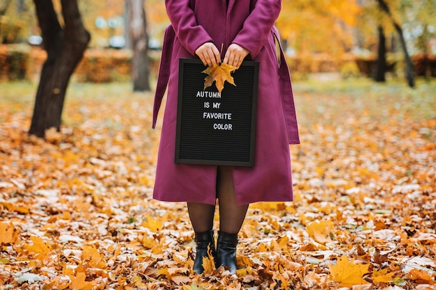 Hello autumn faceless outdoor portrait of woman with letter message board with text autumn is my