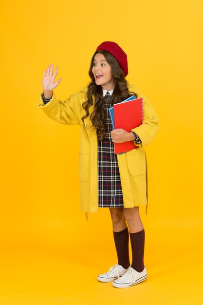 Hello. cheerful child ready for schoolyear. education. happy childhood. notebooks for learning at class. back to school. retro girl wear uniform and parisian beret. kid school fashion.