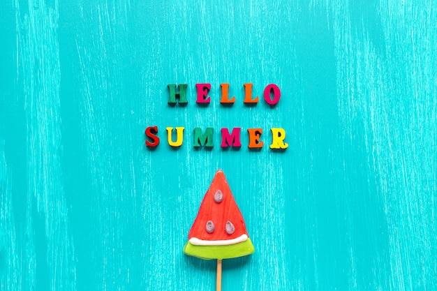 Photo hello summer text and watermelon lollipop on stick. concept creative template greeting card