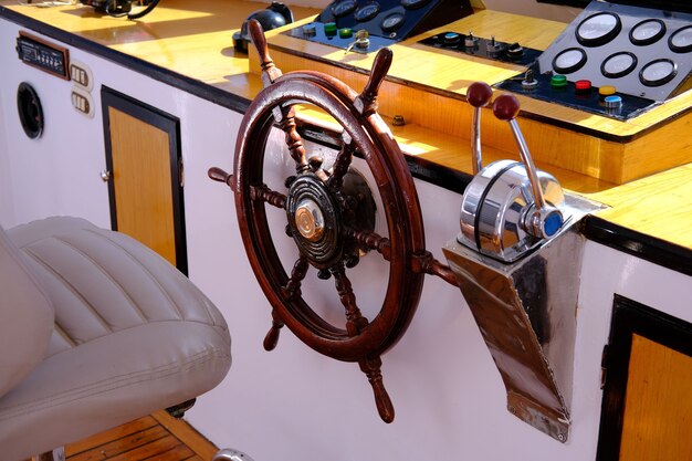 The helm of the yachtcloseup of a vintage hand wheel on a wooden sailing yacht yachting helm of