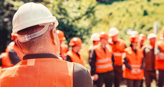 Helmet builder Worker group wearing vest safety Building concept Architector engineers on constructing site Builder man