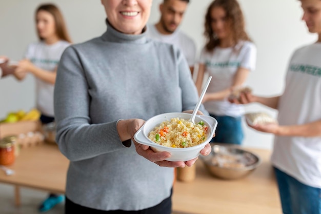 Help for aged people Happy senior woman received food standing in charity organization office and smiling cropped