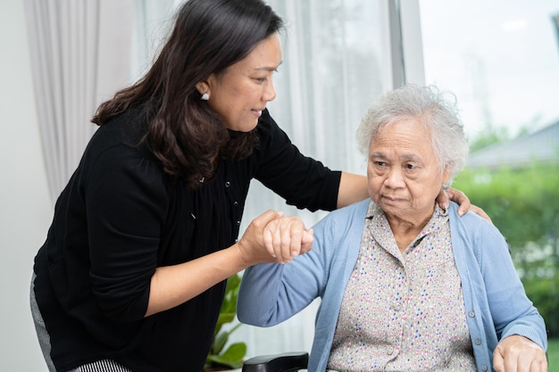 Help and care Asian senior woman patient sitting on wheelchair at hospital