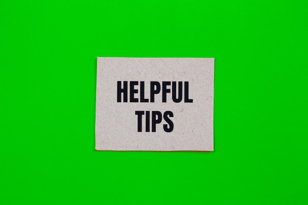 Helpful tips message written on paper piece with green background Conceptual helpful tips symbol Copy space