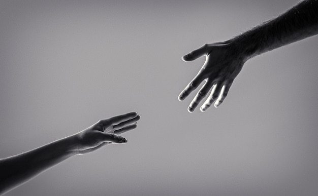 Helping hand outstretched isolated arm salvation Two hands helping arm of a friend teamwork Black and white