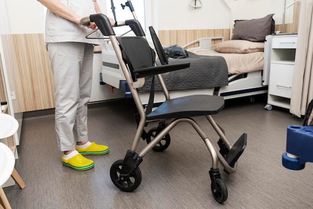 Helping a patient get into bed in a hospital ward A nurse holds a wheelchair by the handle