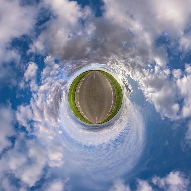 Hemisphere of the planet on an asphalt road stretching beyond the horizon with blue sky and beautiful clouds Spherical abstract aerial view Curvature of space