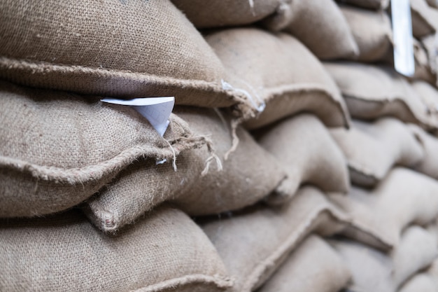 Hemp sacks containing coffee bean in warehouse.