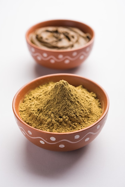 Photo henna or mehandi powder and paste. prepared for hair colouring or for tattoo on hand in indian weddings or festivals. selective focus