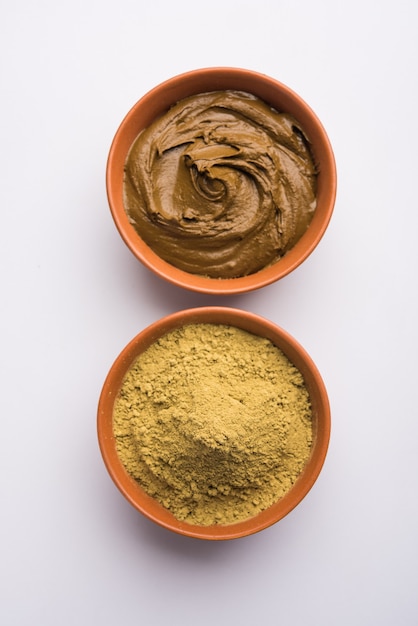 Photo henna or mehandi powder and paste. prepared for hair colouring or for tattoo on hand in indian weddings or festivals. selective focus