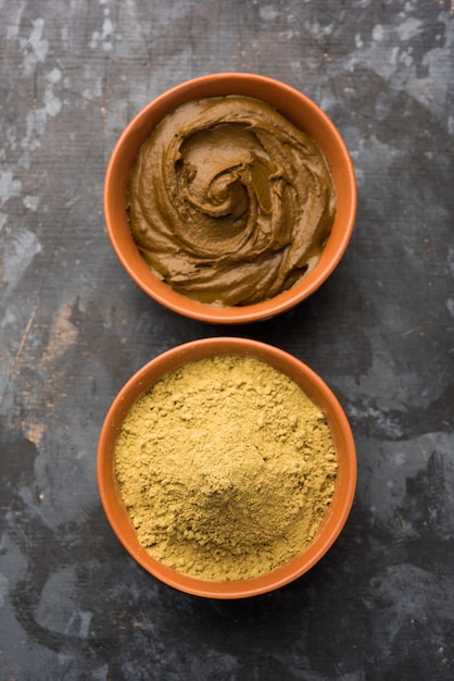 Photo henna or mehandi powder and paste. prepared for hair colouring or for tattoo on hand in indian weddings or festivals. selective focus