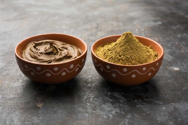 Photo henna or mehandi powder and paste. prepared for hair colouring or for tattoo on hand in indian weddings or festivals. selective focus