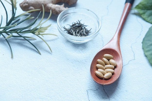 Herbal medicine on spoon and herbs on table