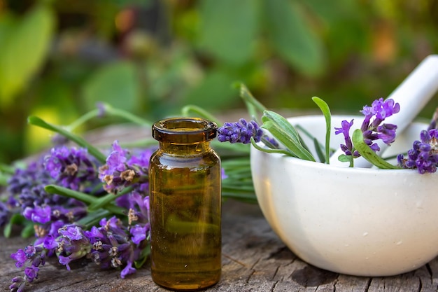 Herbal oil and lavender flowers on a wooden background Nature