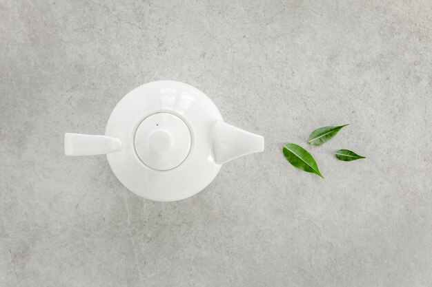 Photo herbal tea in a white teapot with green tea leaves flat lay top view tea concept