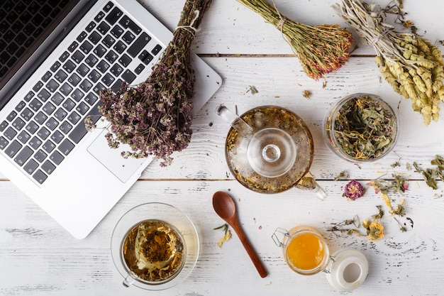 Herbal tea with laptop and herbs