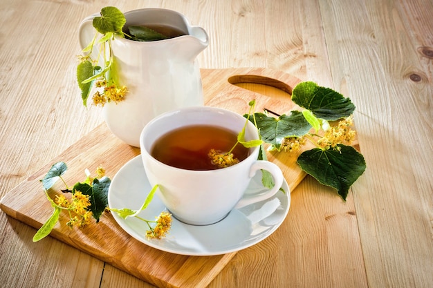 Herbal tea with Linden flowers on wooden table for good health.