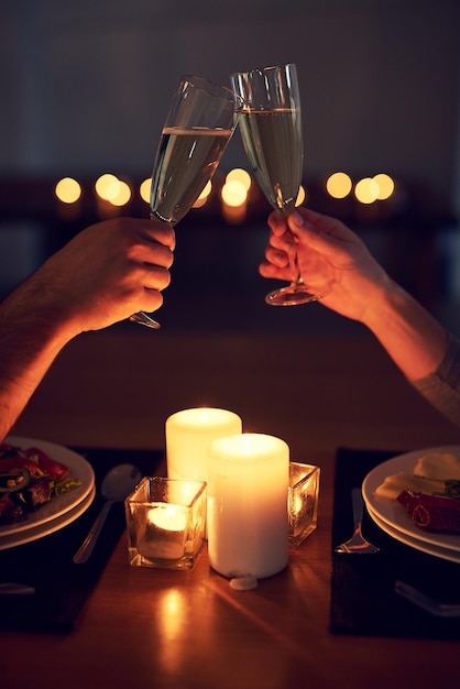 Heres to us and our future Cropped shot of an unrecognizable couple having a celebratory toast over a candle lit dinner at night