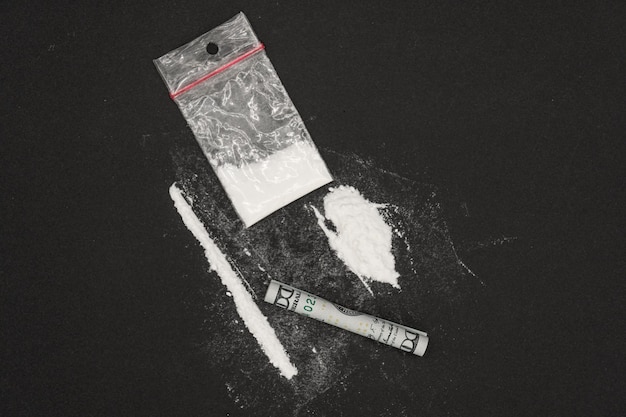 Heroin or other illegal drugs, white powder on a black background.