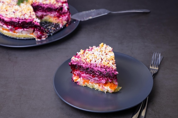 Herring salad under a fur coat Traditional Russian multilayered salad from herring beets potatoes carrots and eggs Closeup grey background