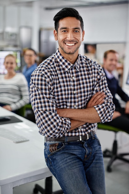 Hes a manager you can trust Portrait of a laughing businessman with his colleagues in the background