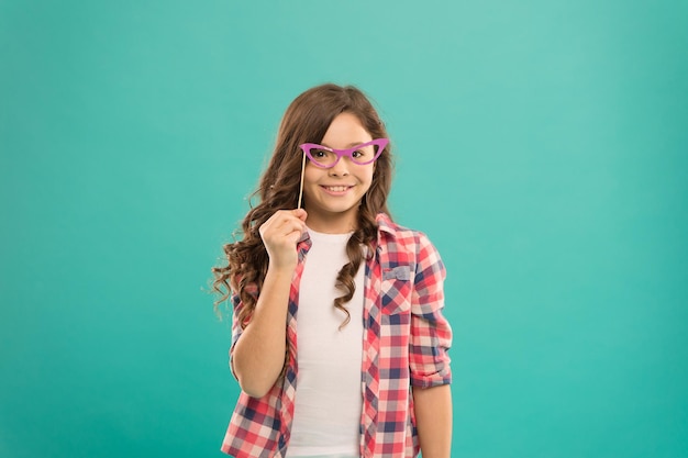 Hey just have fun Funny small girl holding glasses photo booth props on stick Cute kid with fancy party props Party decorations Party shop Celebration Happy little child Start this party